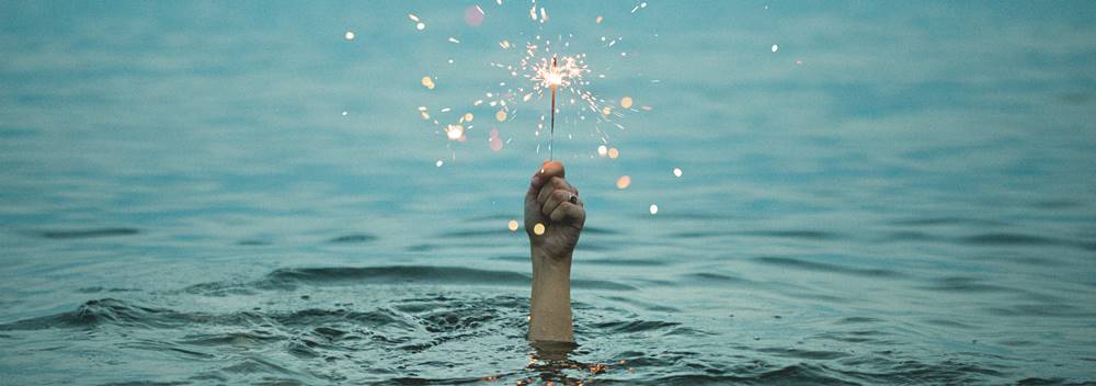 Una mano che regge una scintilla, un simbolo di verità